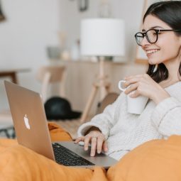 woman having coffee while using laptop